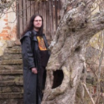 Andr� J.C. Bor before entrance to the monastery, with the wicked tree....